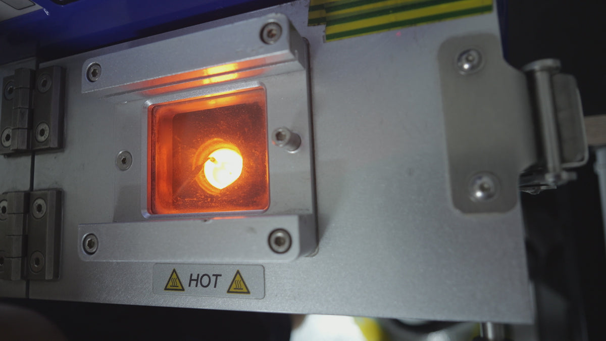Orange glow inside the melting chamber as gold is heated before pouring into a jewellery mould.