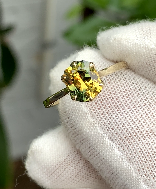 Yellow and green sapphire in a claw setting on a slender polished band.